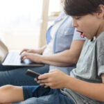 Garçon surpris et choqué sur son téléphone portable